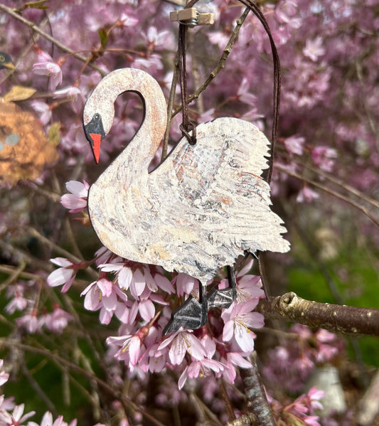 wooden swan decoration hanging on cherry blossom tree