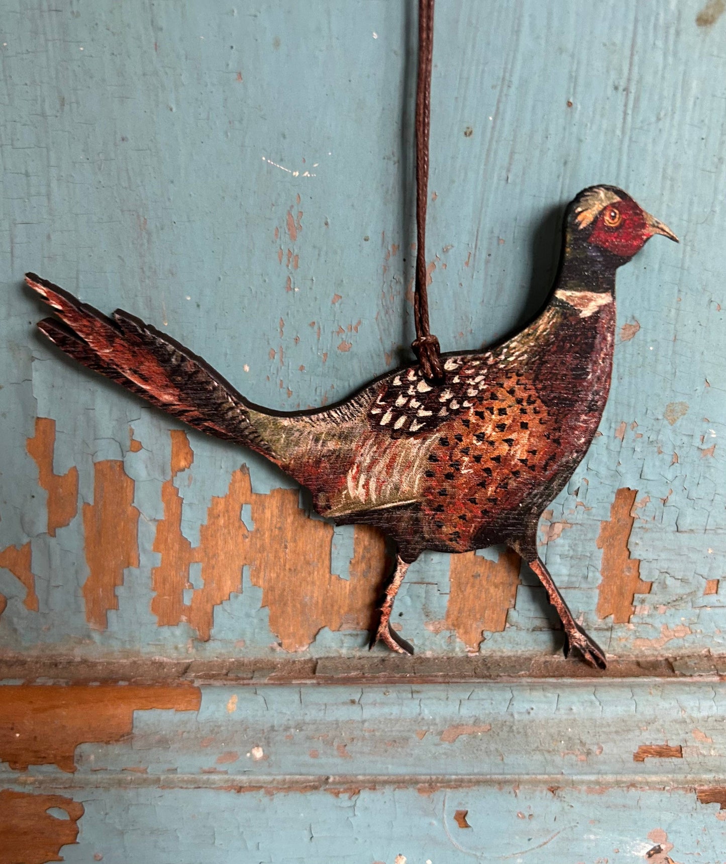wooden pheasant decoration on brown waxed cord