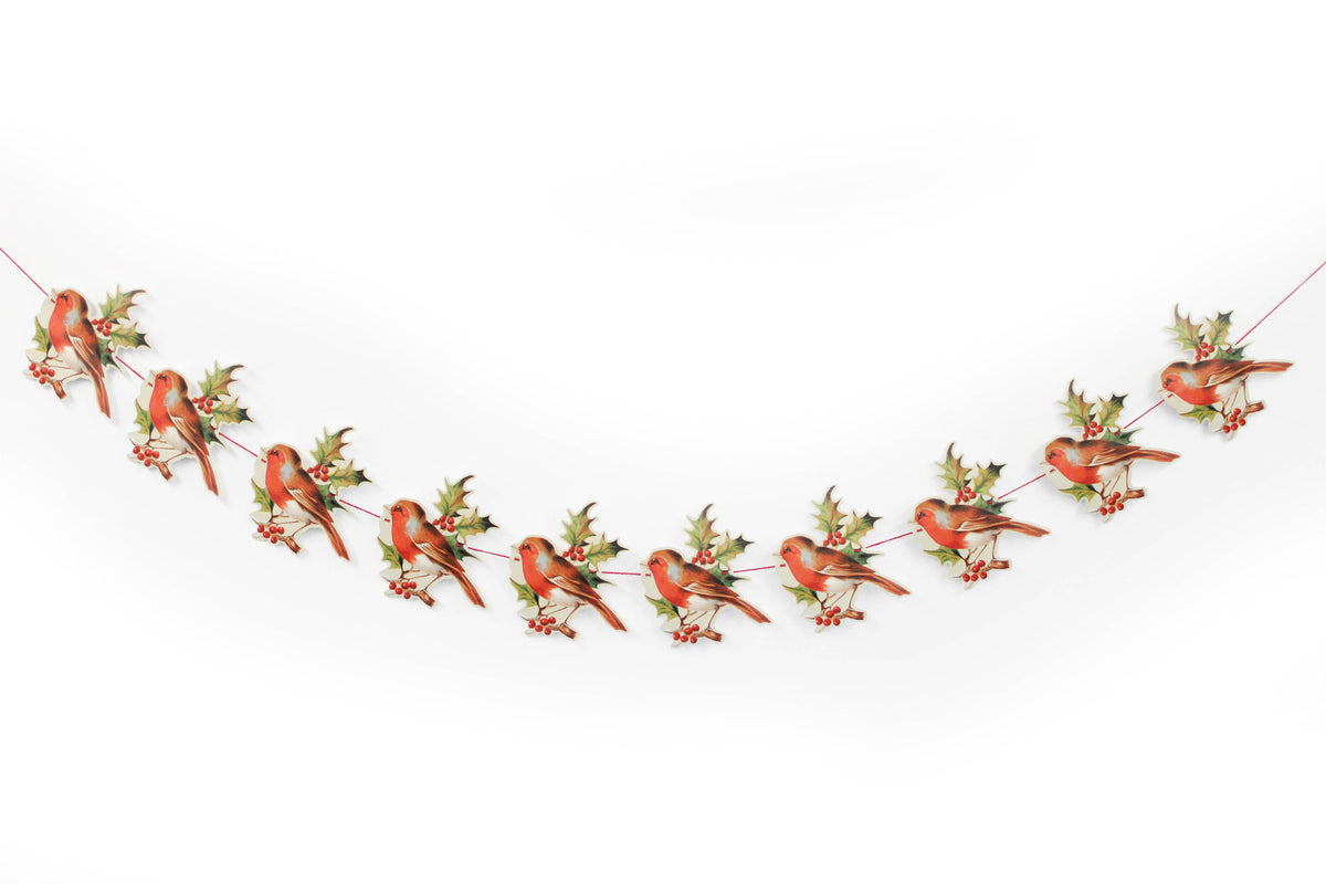 Die-cut paper robin perched among holly leaves