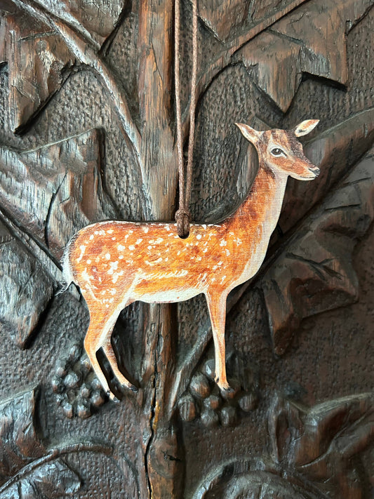 Plywood, eco Decorative deer ornament hanging on a textured wooden surface