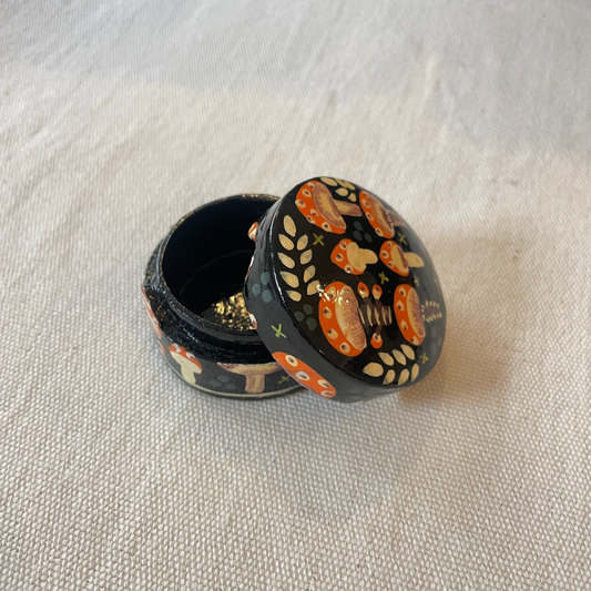Mini hand-painted papier mâché trinket box with toadstool design on linen background