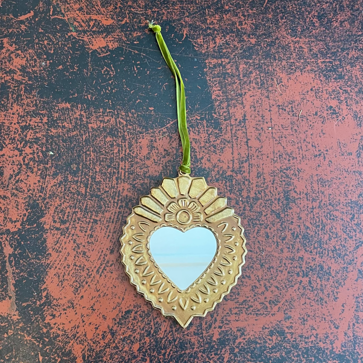 Decorative heart-shaped mirror with a green velvet ribbon