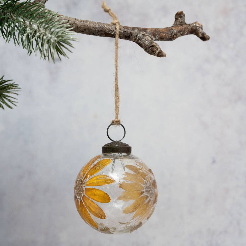 Mouth-blown Christmas bauble with zinnias and foliage within the glass