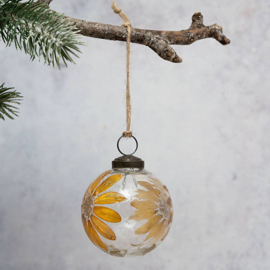 Mouth-blown Christmas bauble with zinnias and foliage within the glass