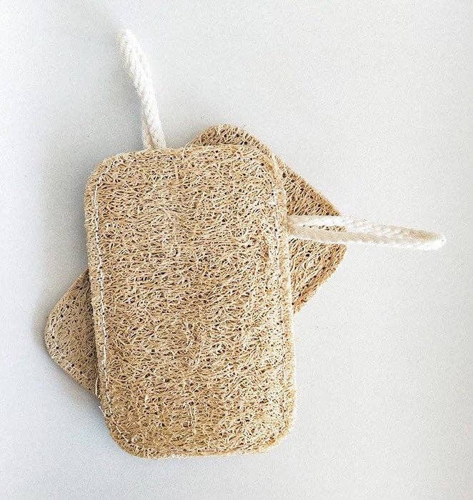Flat lay of multiple loofah sponges arranged neatly on neutral background