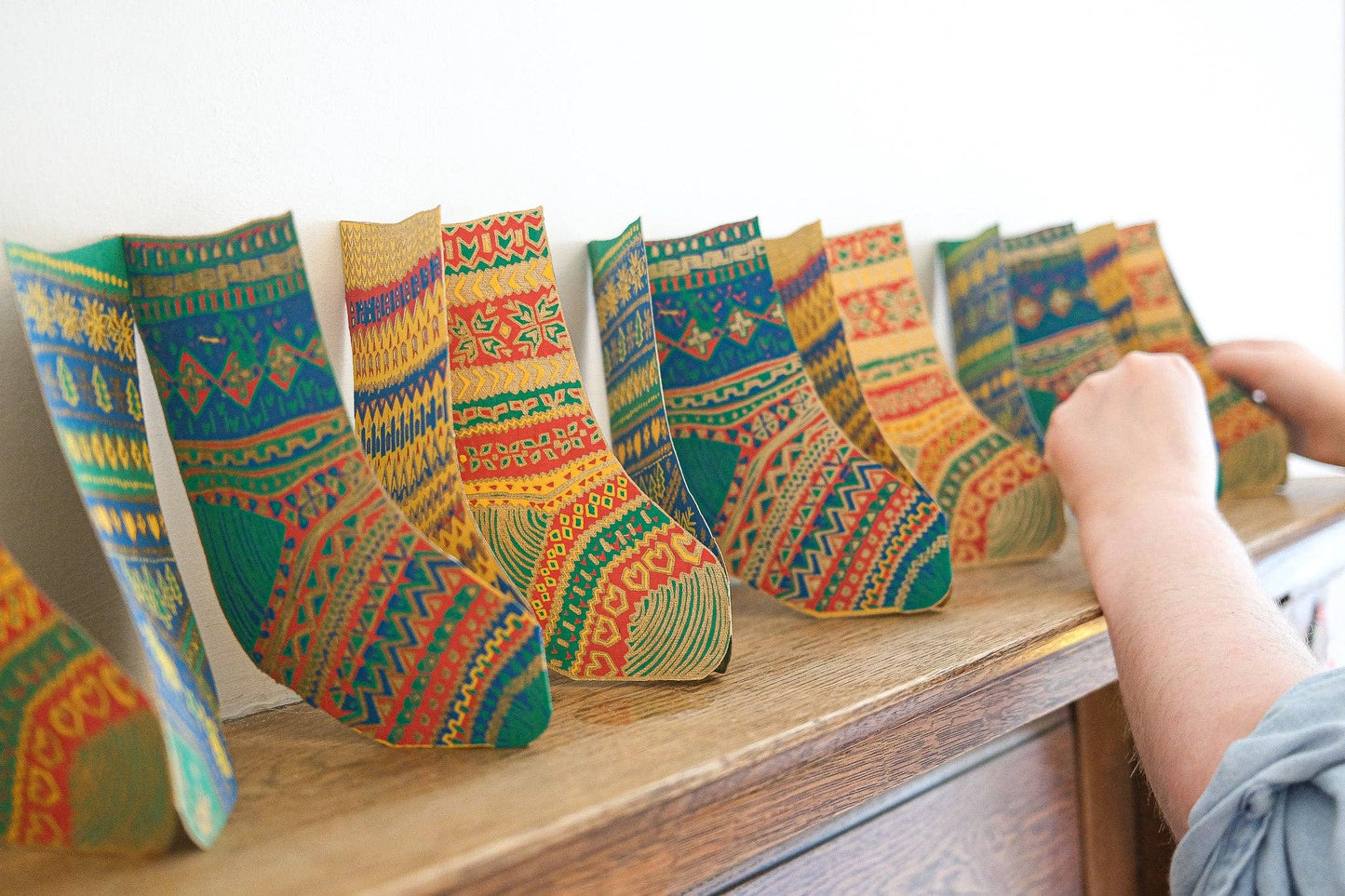 Colorful patterned paper socks garland n a wooden surface