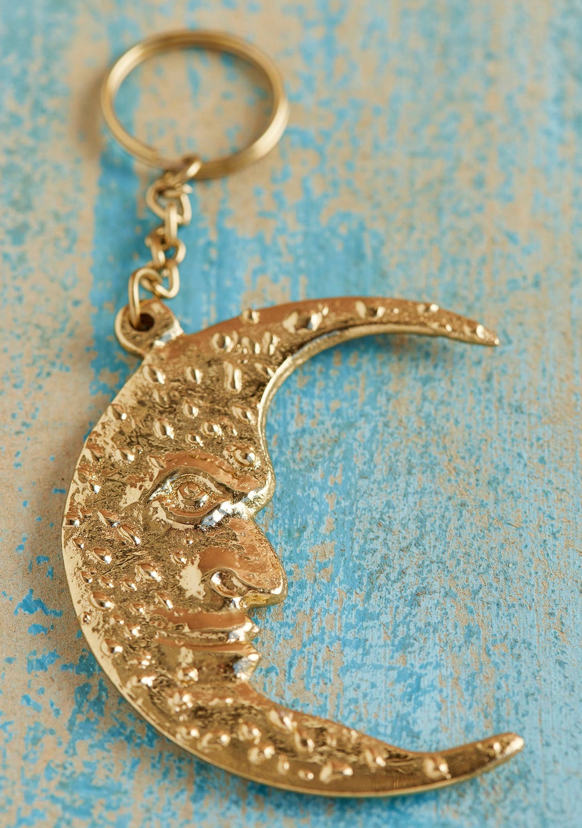 Gold-coloured crescent moon face keyring in recycled aluminium