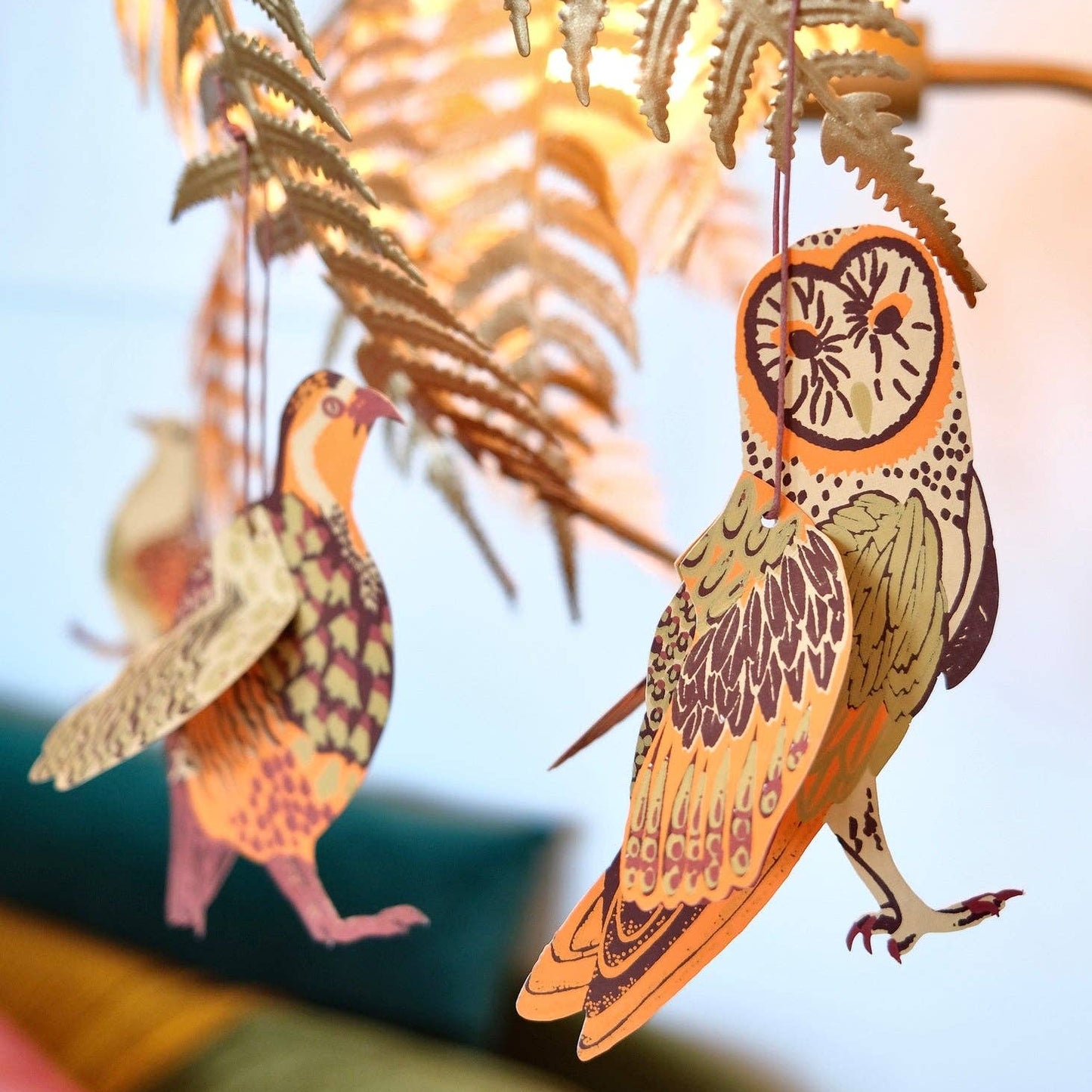 Decorative paper birds hanging from a branch 