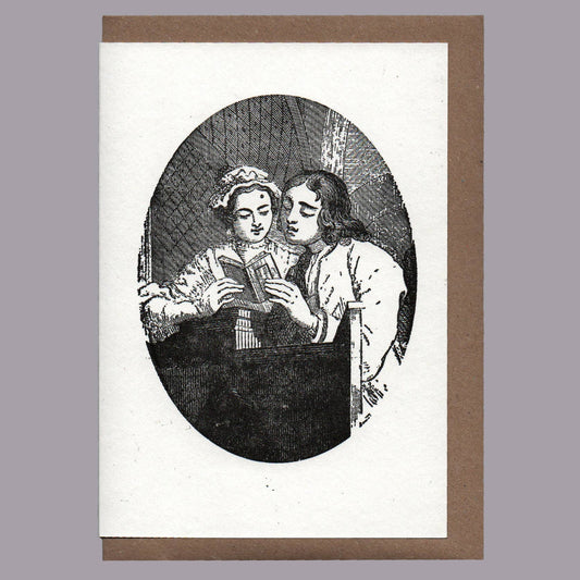 Greetings Card with Vintage-style illustration of two people reading a book, framed with a brown border on a gray background.