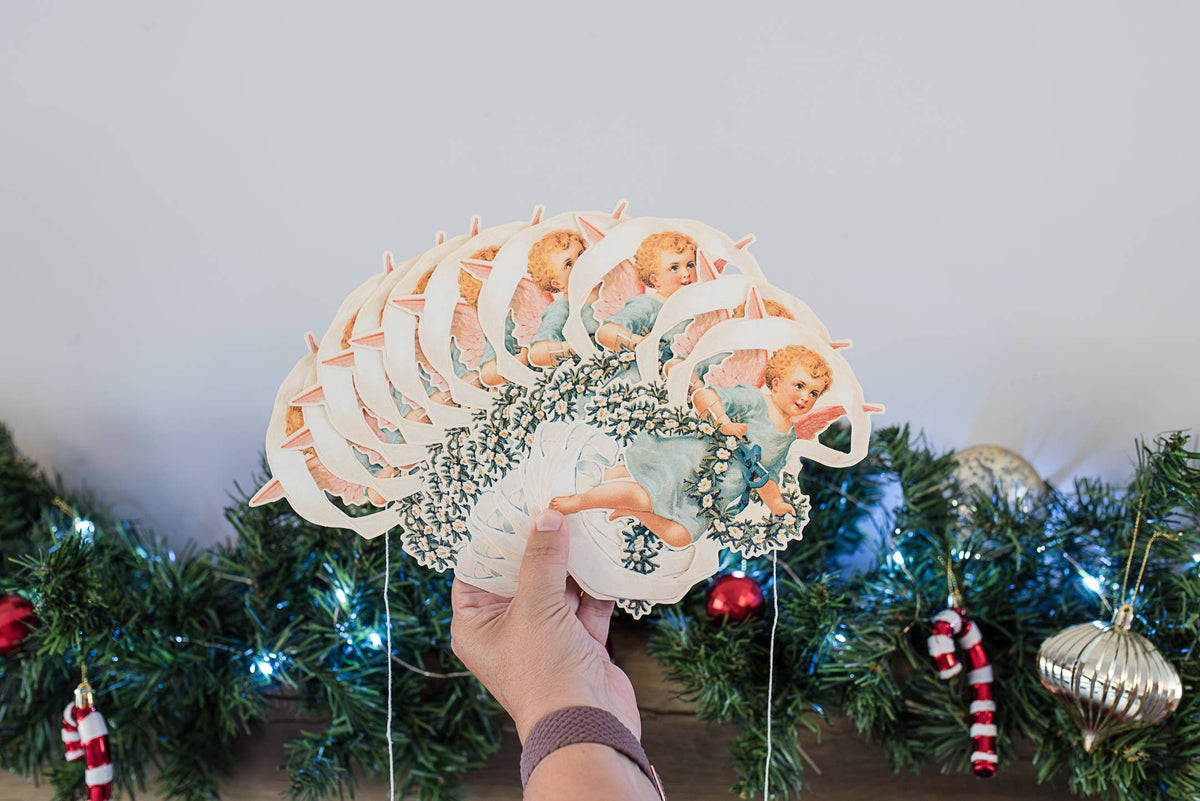Embossed paper cherub garland hanging on a string