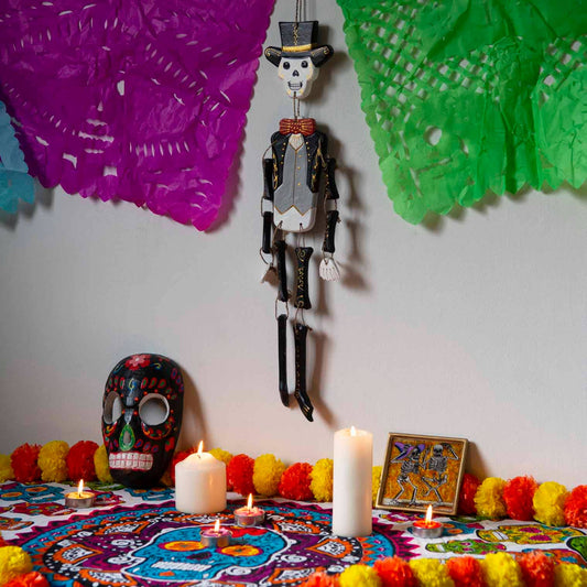 Day of the Dead calaca figure painted in bright candy-skull patterns