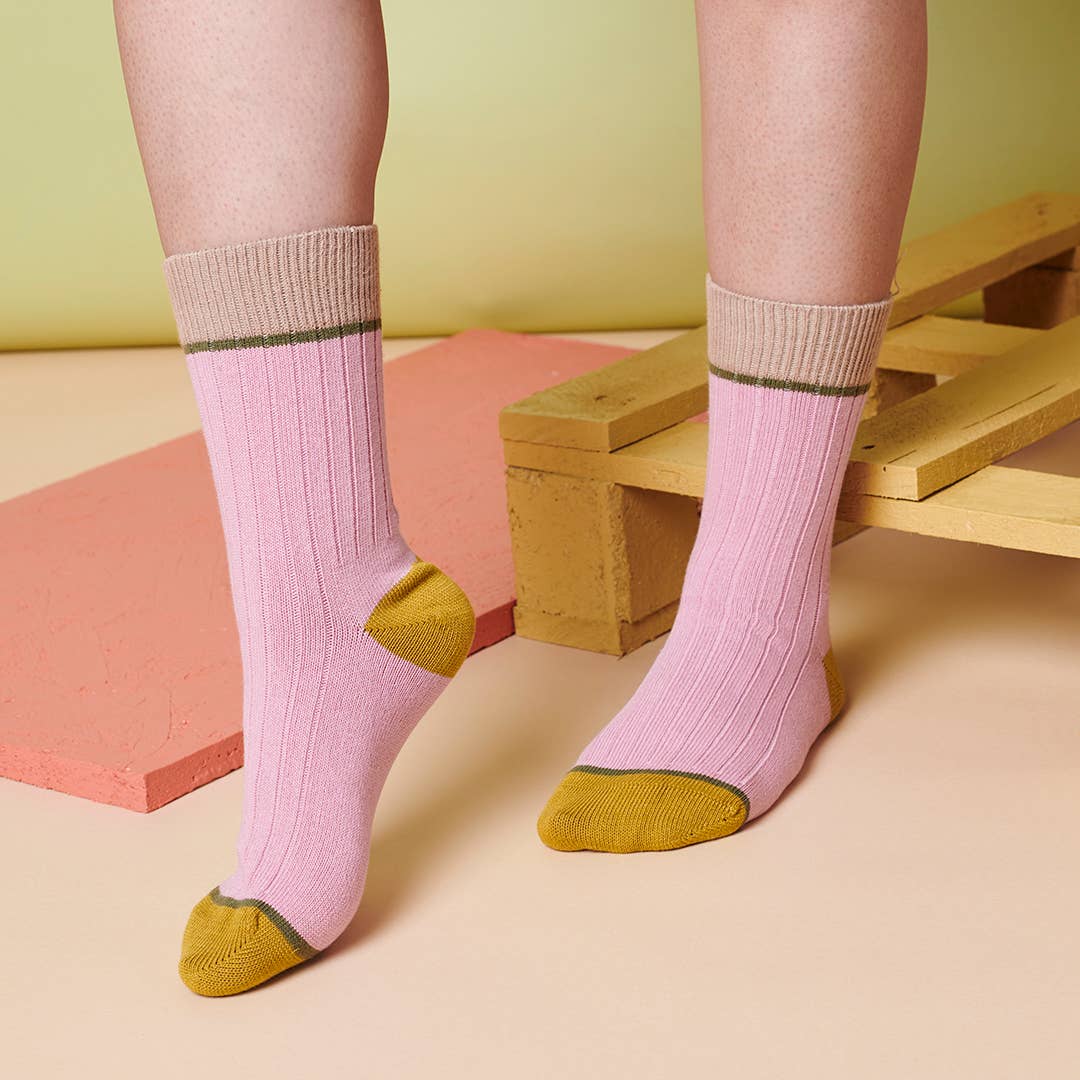 Organic cotton pink socks with yellow toes and cuffs worn by a person