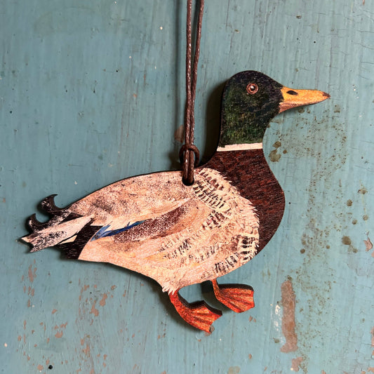 Wooden duck ornament hanging on a rustic blue wooden surface