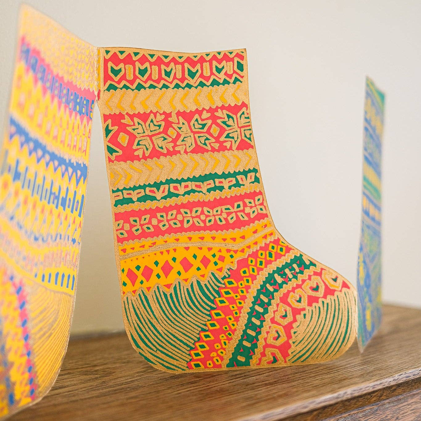 Colorful patterned socks decorations on a wooden surface with a neutral background
