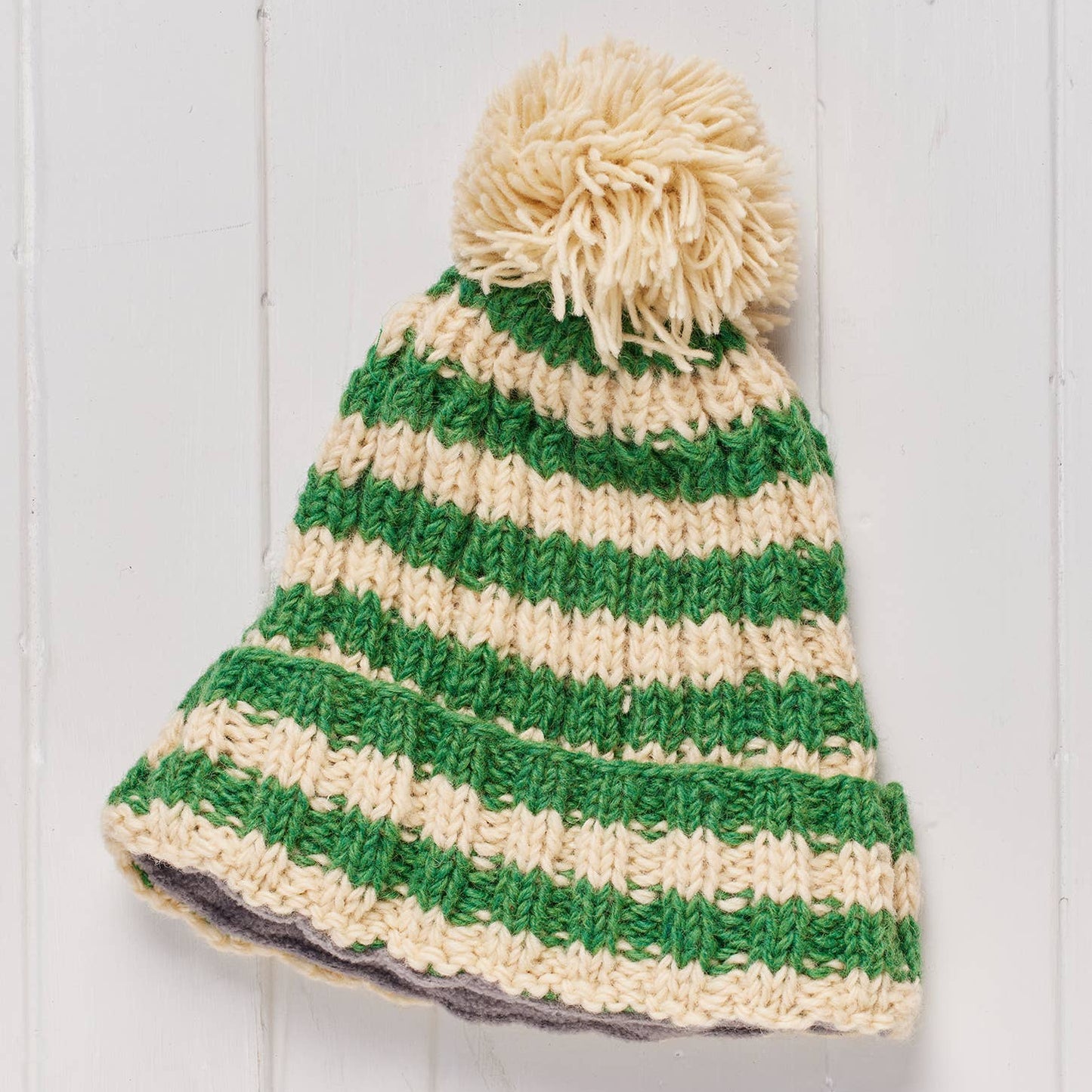 Green and beige striped beanie with a pom-pom 