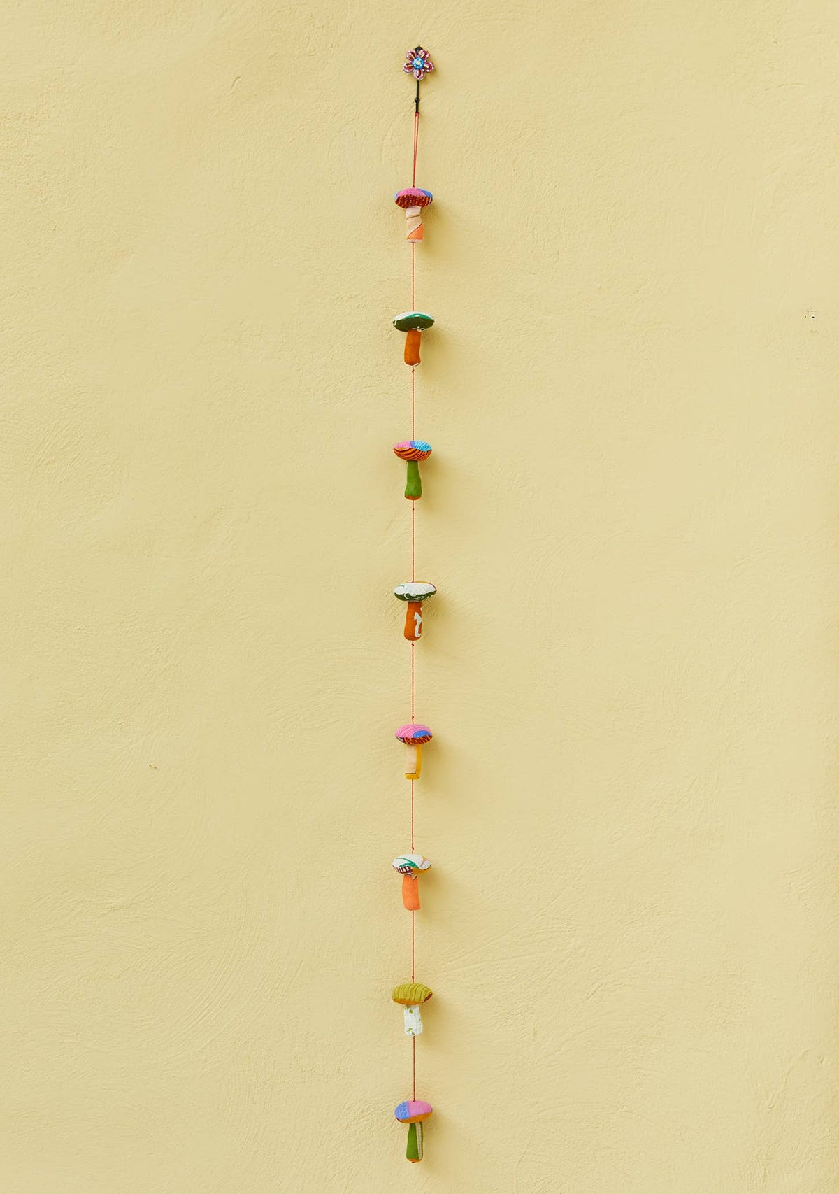 Mushroom sari garland hanging in a window