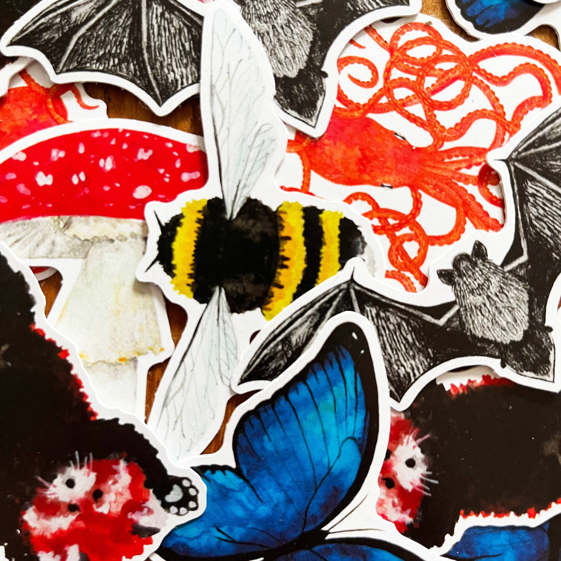 Collection of various stickers including bats, a butterfly, and other designs on a white background.