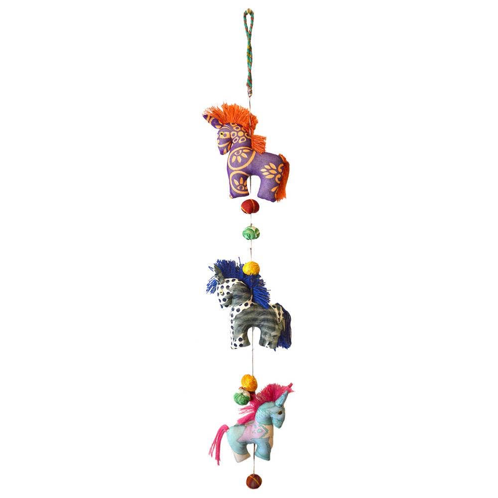 Colorful horse-shaped toy mobile hanging from a vertical string on a white background